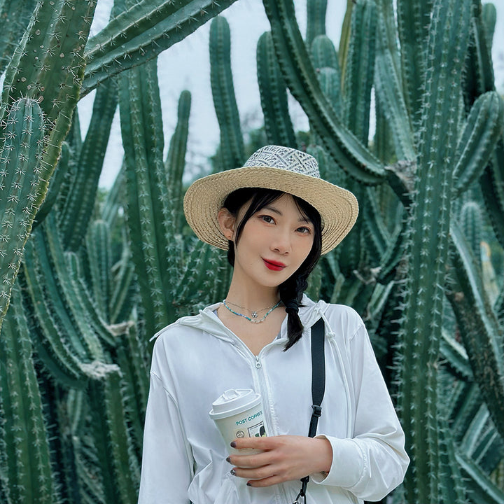 a woman standing in front of a cactus holding a cup of coffee